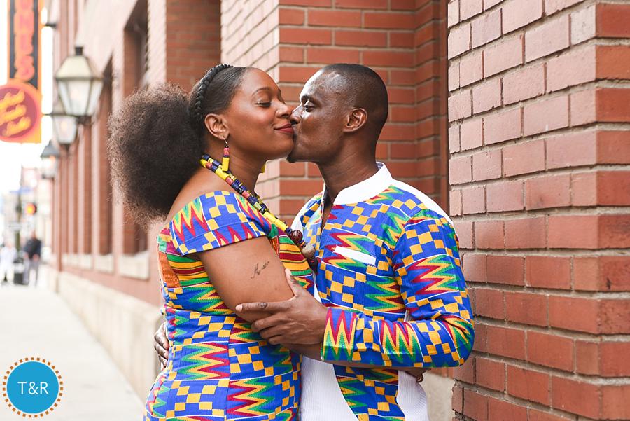 A couple embraces in their colorful African outfits before their multicultural Detroit wedding