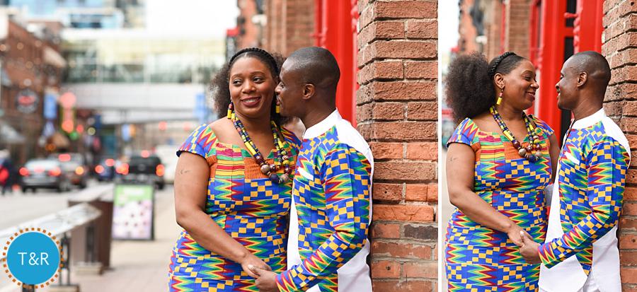 A couple embraces on the sidewalk in Detroit's Greektown in colorful African outfits