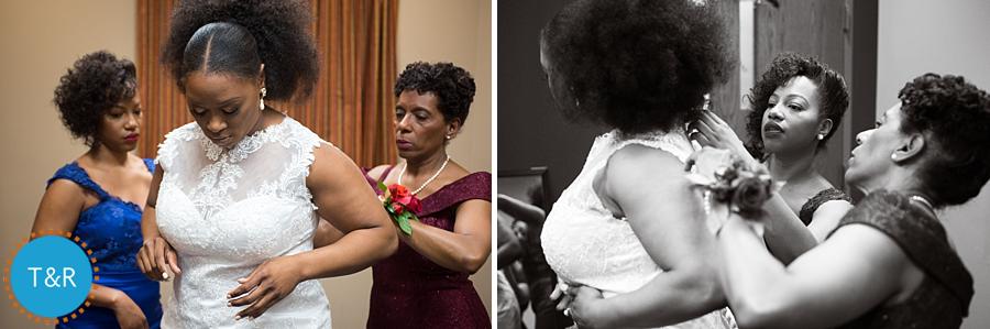 A bride receives help from her mother and sister as she puts on her wedding dress