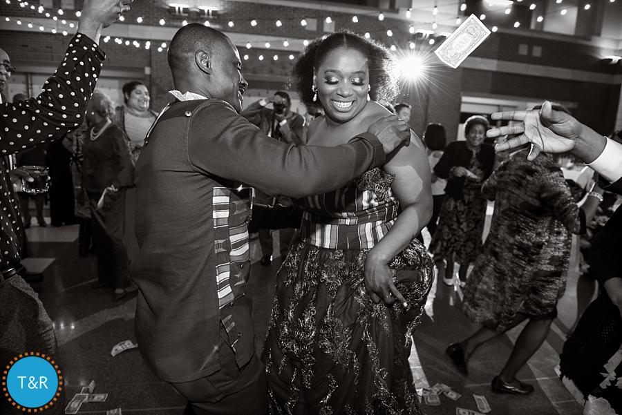 Money flies as a couple dances during a traditional African money dance at the Rattlesnake club