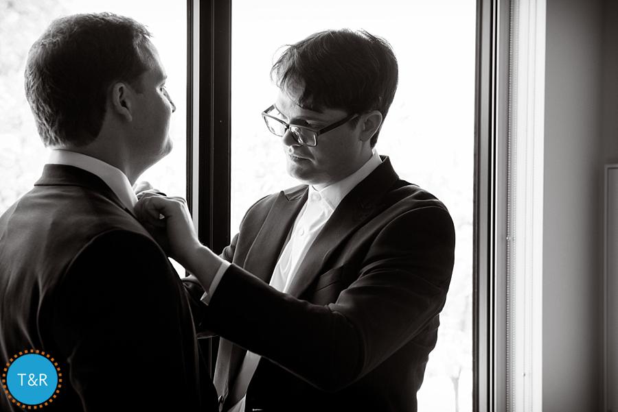 A groomsman helping the groom with his tie