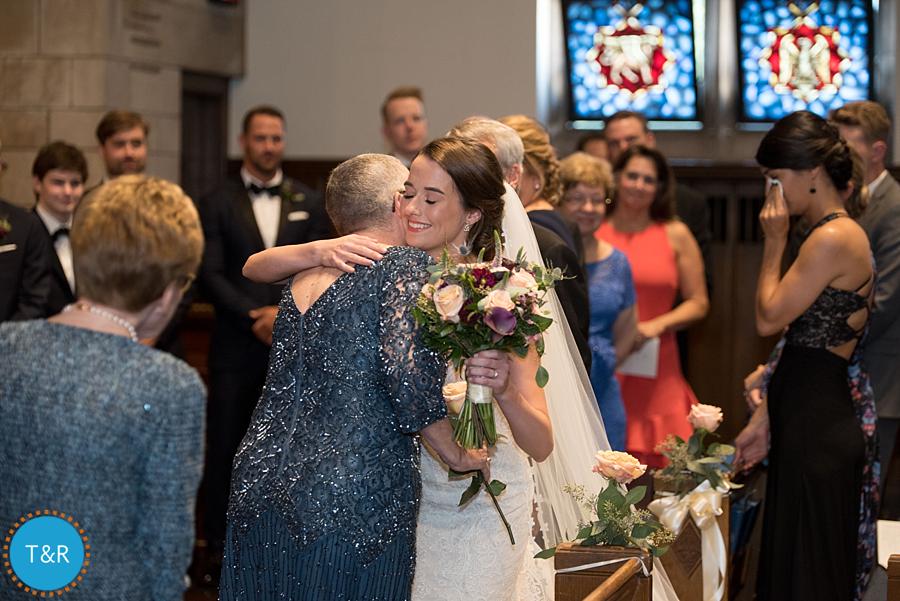 The bride, hugging family as she walks down the aisle