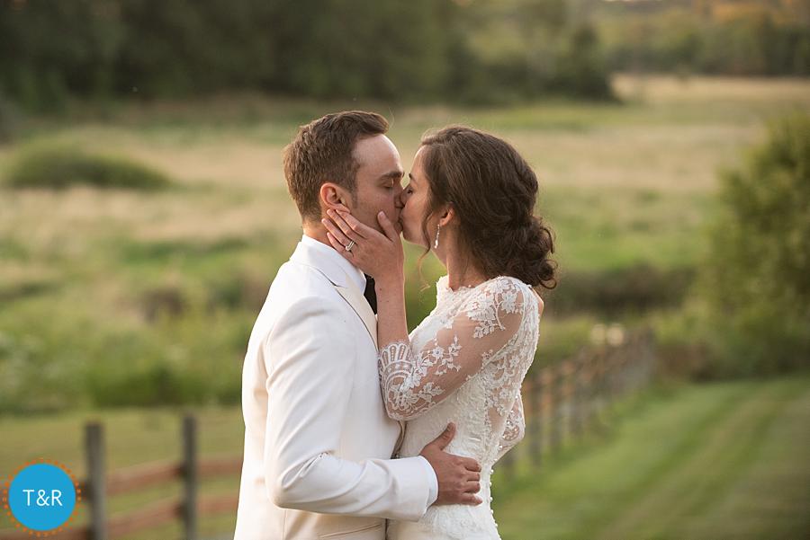 bride and groom embrace and kiss