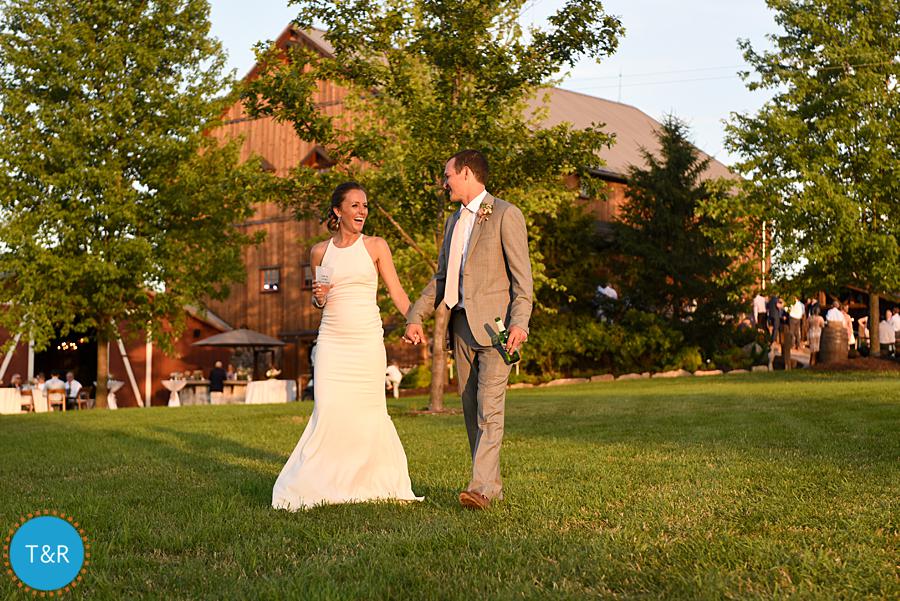Bride and groom take a walk outside the barn at their wedding reception at Frutig Farms The Valley