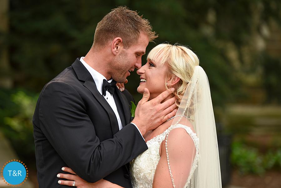 Bride and groom embrace during wedding photos at the Law Quad in Ann Arbor