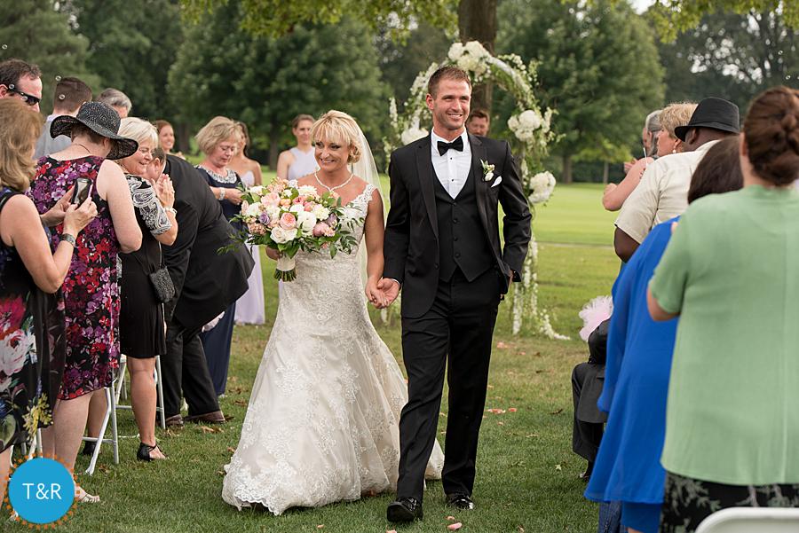 Bride and Groom walk up the aisle after their wedding ceremony at Travis Pointe Country Club