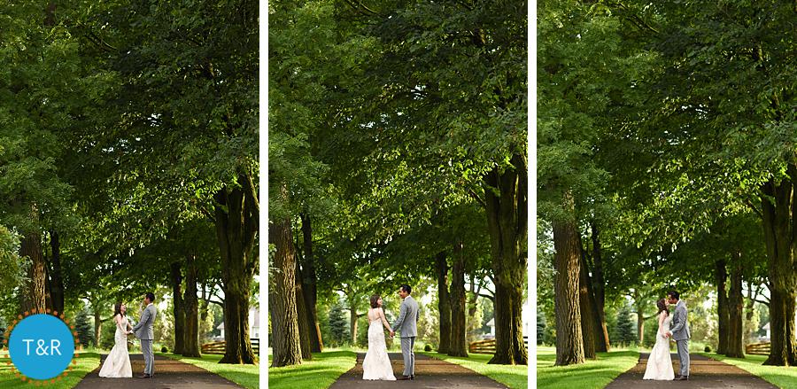 Bride and groom embrace and kiss playfully under the trees on the grounds at Zingerman's Cornman Farms Wedding in Ann Arbor