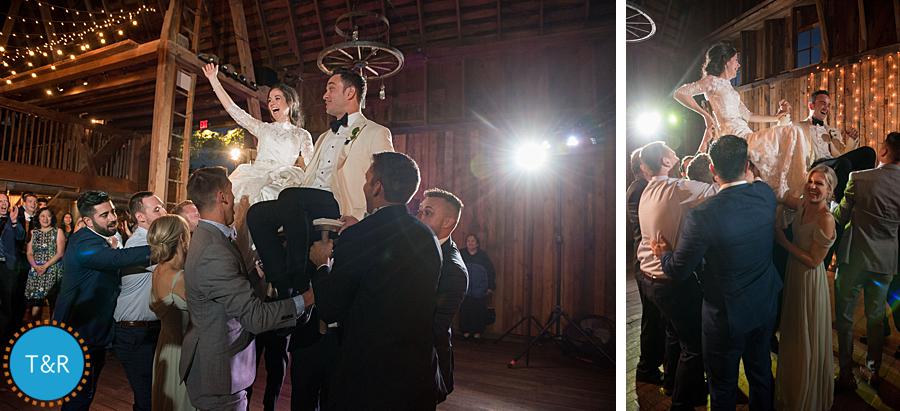 Bride and groom dance with guests inside the barn at Frutig Farms Misty Farm during their Ann Arbor wedding reception